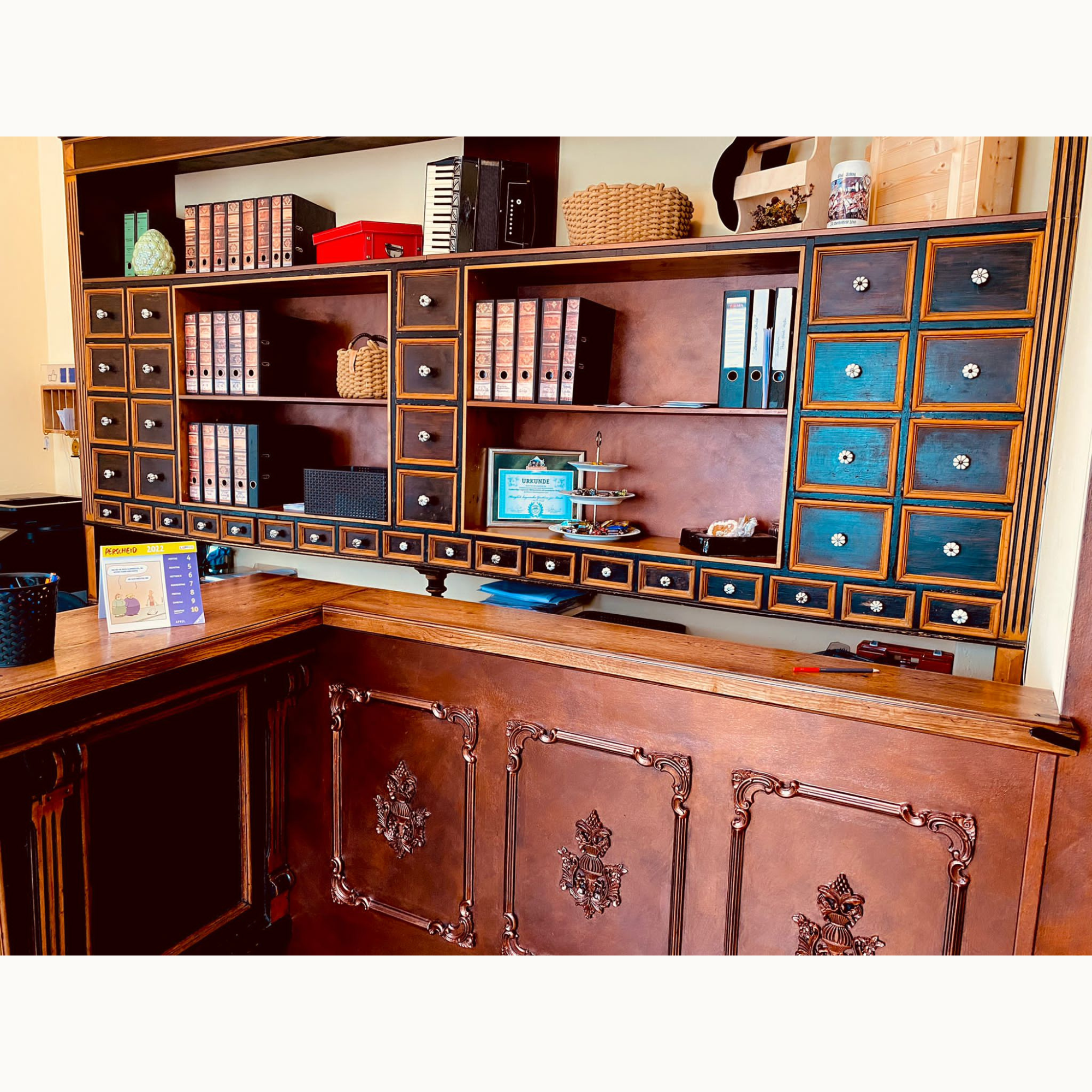 Großes Regal im Apotheker-Stil mit vielen Schubladen und barock verzierter Front