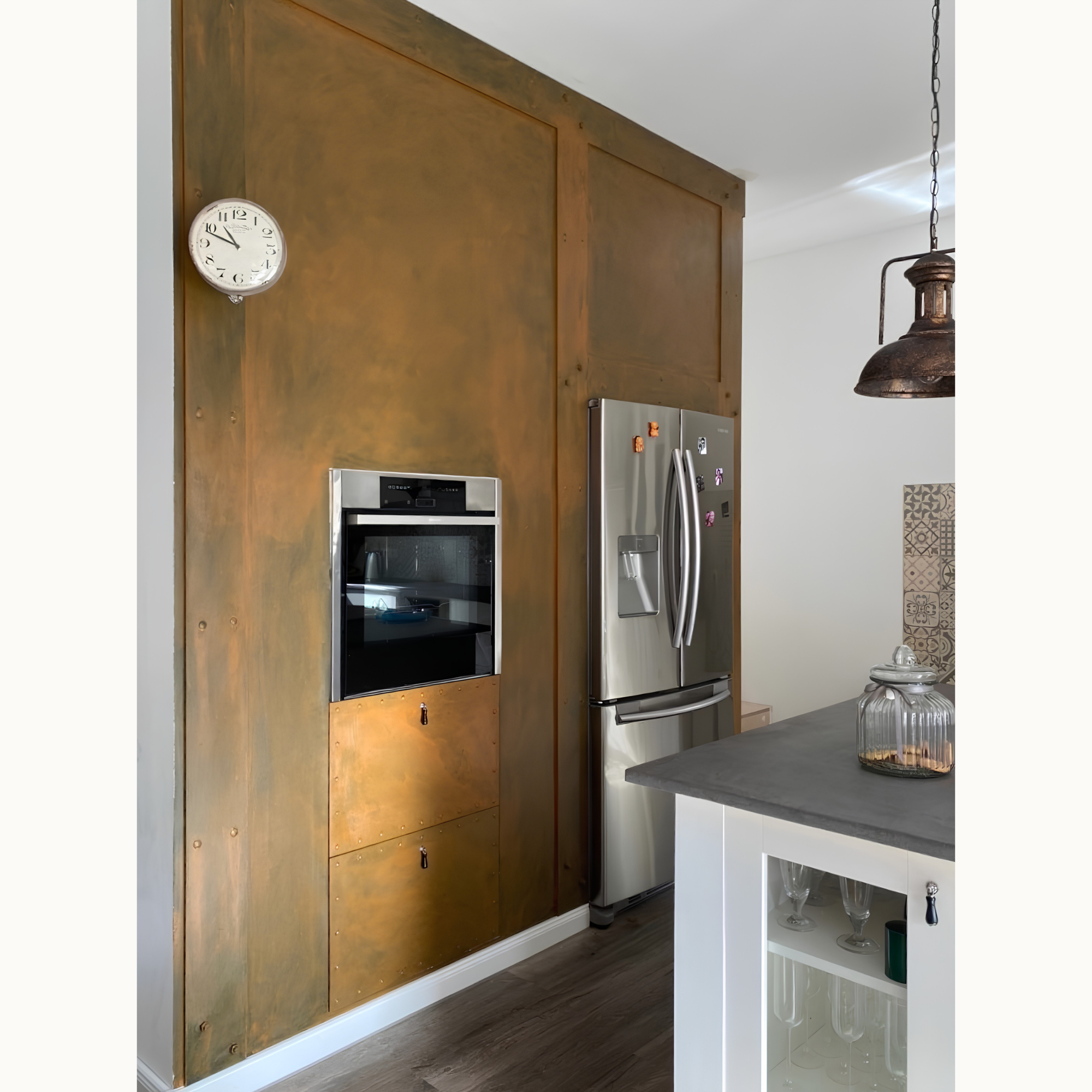 Küchenwand in rost Metallic-Look mit Einbaubackofen, Kühlschrank und weißer Wanduhr